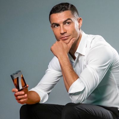 Cristiano Ronaldo holding a bottle of his fragrance.
